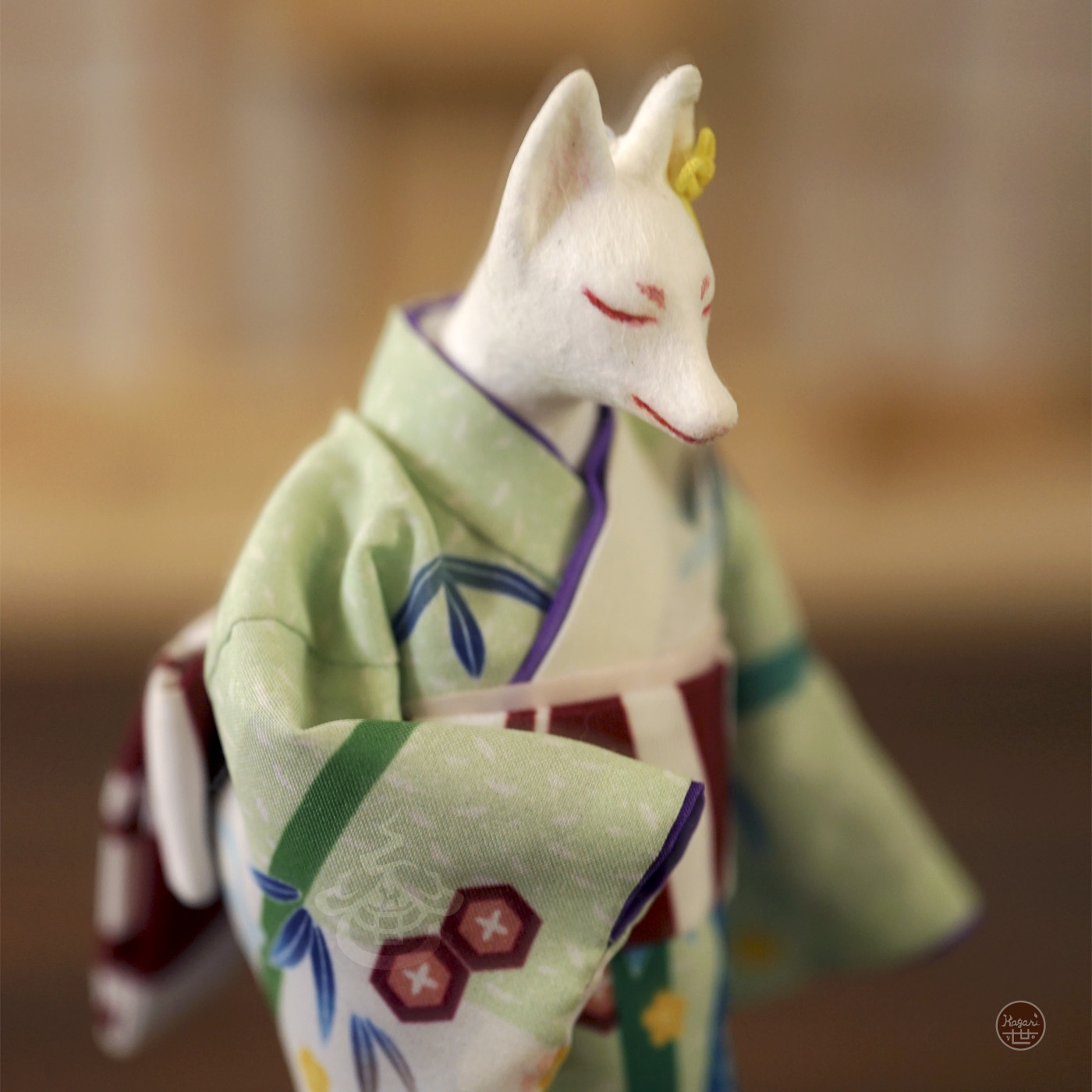 Close-up of a kimono-wearing fox figure with a pale pink obiage sash and purple layered collar