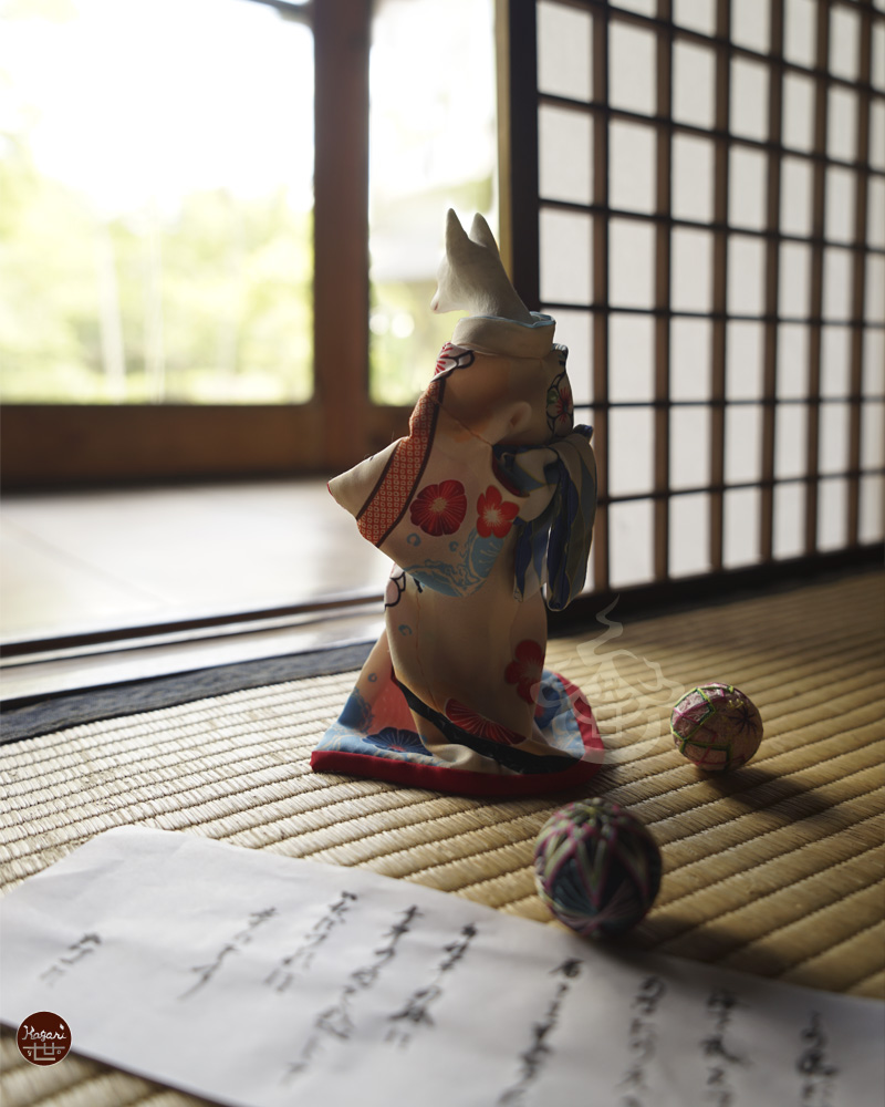 Fox looking outside from a tatami room with an open letter and temari ball