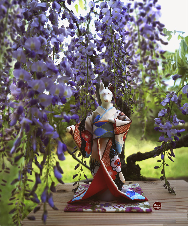 Kimono-wearing fox in a wisteria scene