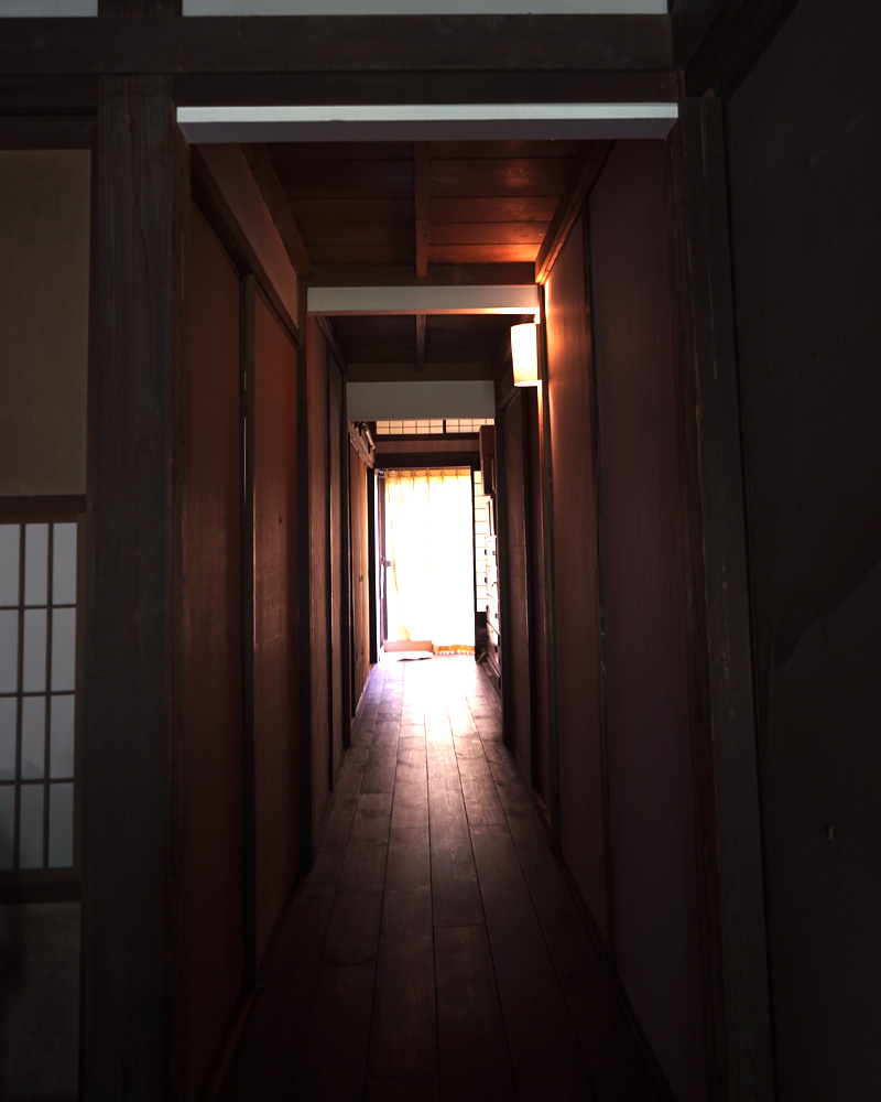 Old Japanese house hallway with a contrast between the dark foreground and soft light beyond